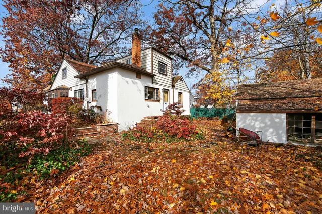 a white house that has a tree in front of it