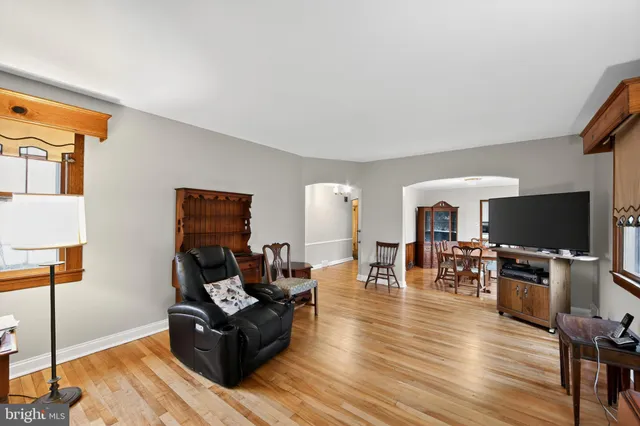 a living room with furniture a flat screen tv and a table