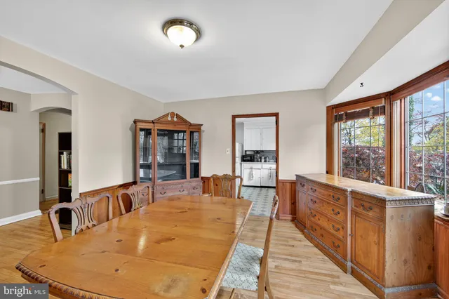 a dining hall with stainless steel appliances granite countertop a dining table and chairs with wooden floor