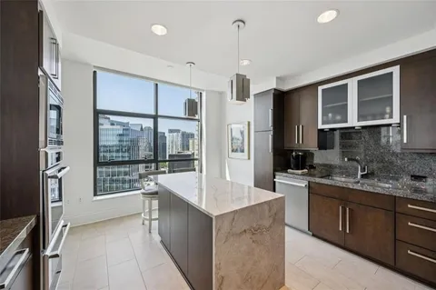a large kitchen with kitchen island a sink stainless steel appliances and cabinets