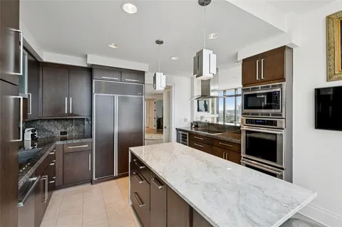 a kitchen with kitchen island a counter space a sink appliances and cabinets