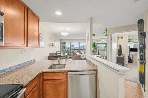 a kitchen with stainless steel appliances granite countertop a sink a stove and a wooden cabinets