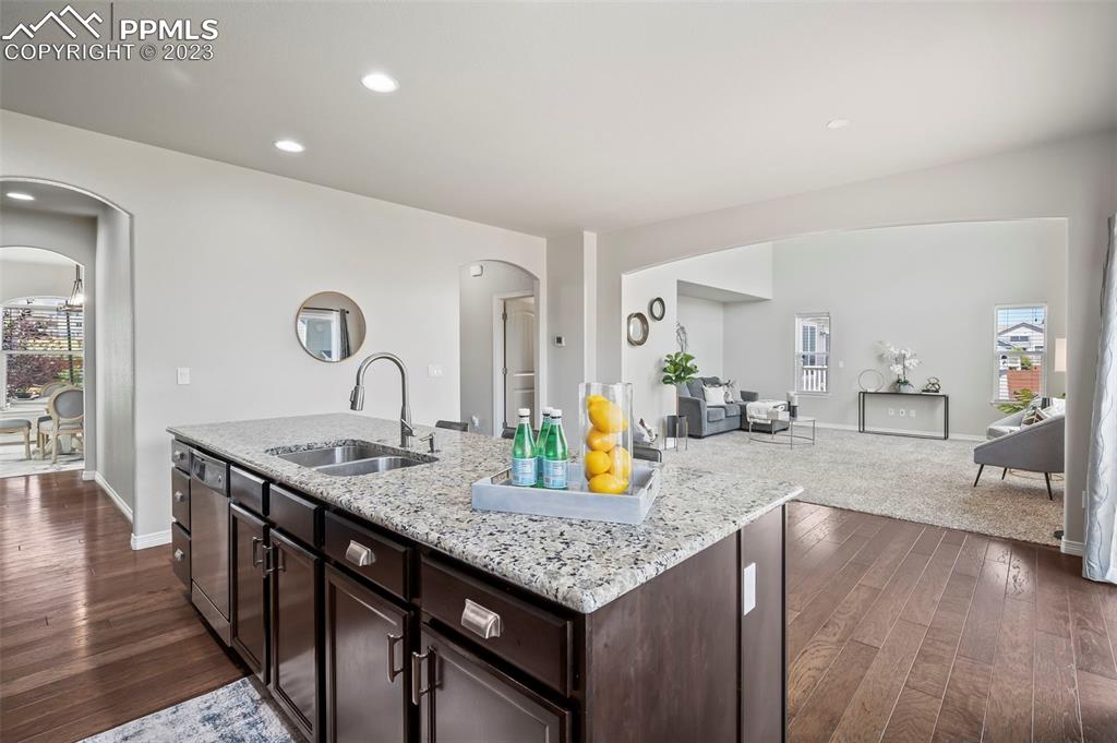 13232 Park Meadows Drive Peyton, CO 80831 - Photo 11 of 23 a kitchen with granite countertop a table chairs and wooden floor