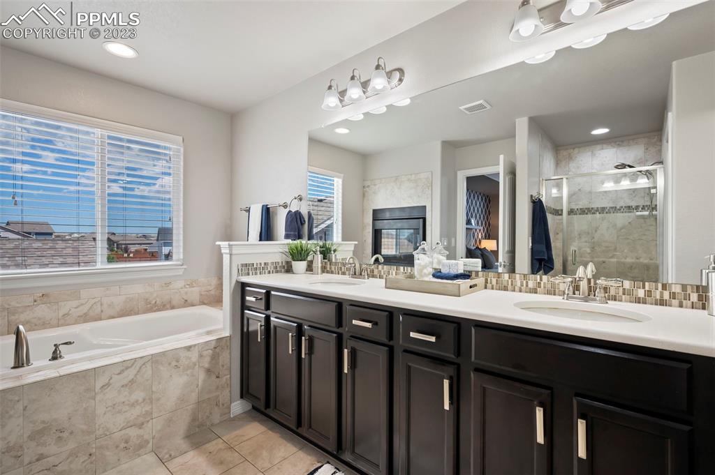 13232 Park Meadows Drive Peyton, CO 80831 - Photo 19 of 23 a bathroom with a granite countertop sink mirror and a bathtub