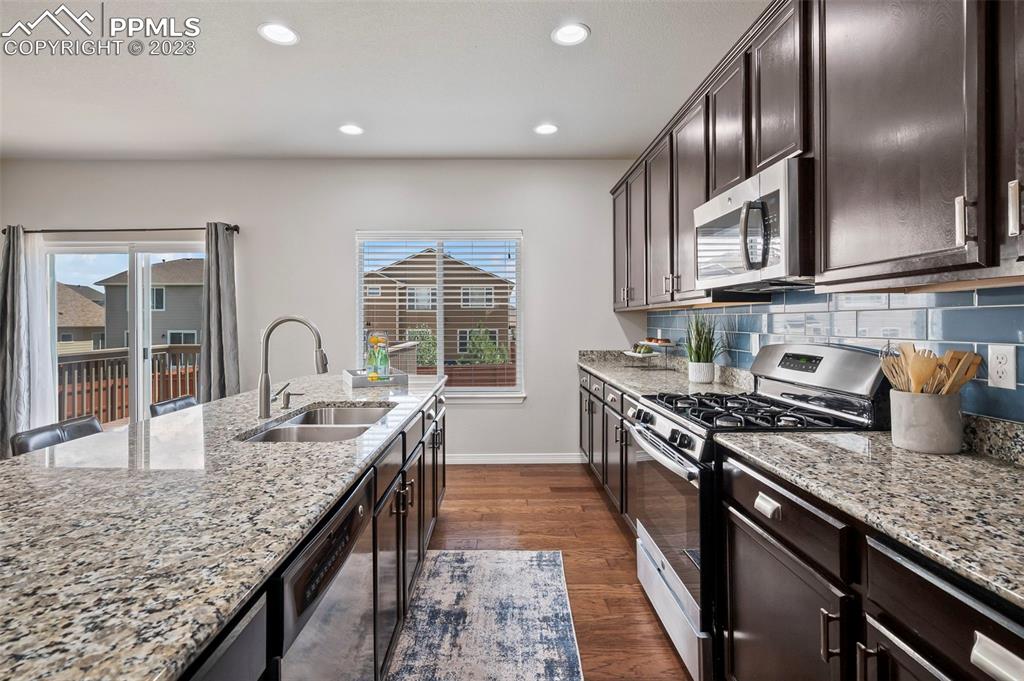 13232 Park Meadows Drive Peyton, CO 80831 - Photo 9 of 23 a kitchen with granite countertop stainless steel appliances window a sink and a counter space