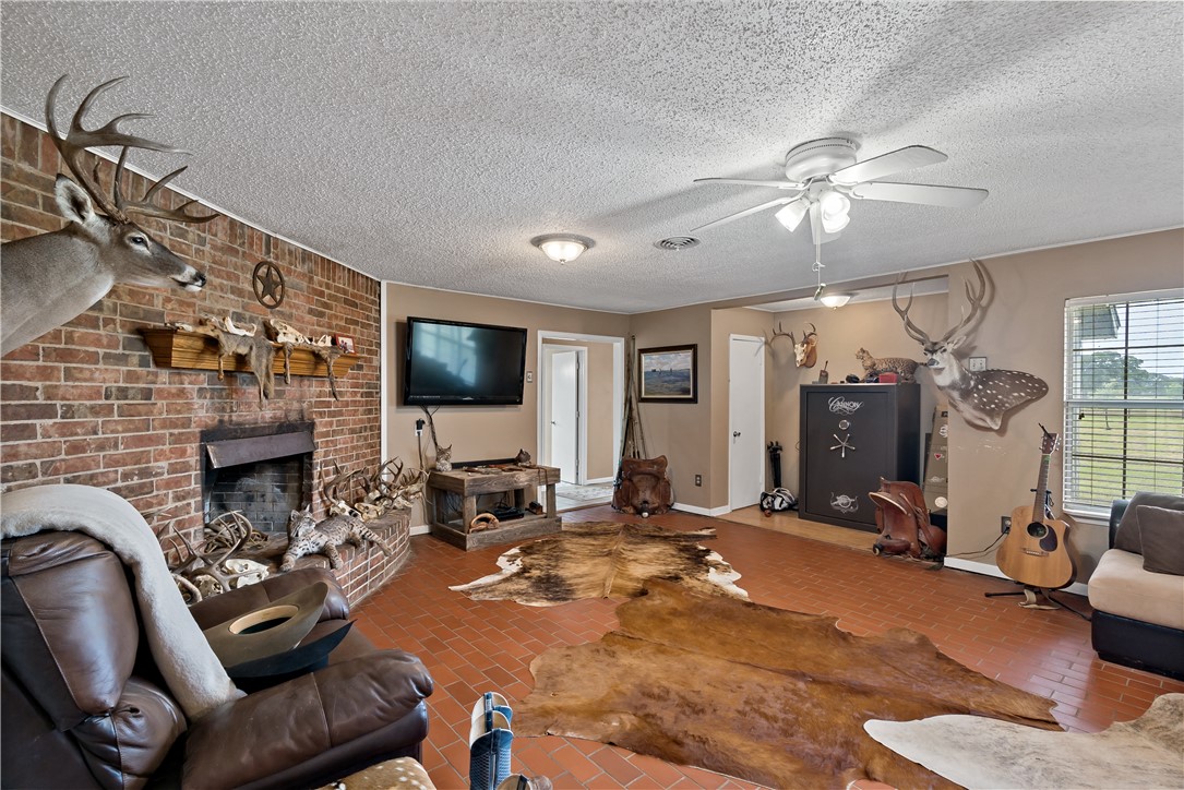 8166 Riley Road Bryan, TX 77808 - Photo 15 of 47 a living room with furniture a flat screen tv and a fireplace
