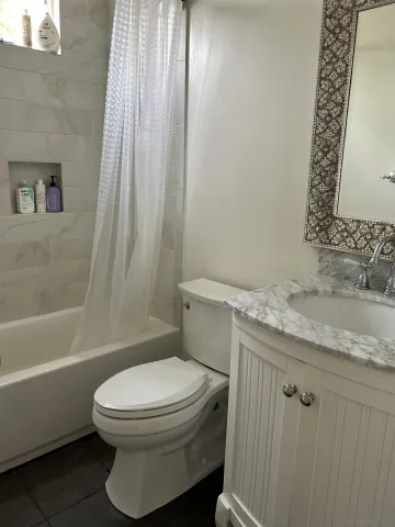 a white toilet sitting next to a bath tub