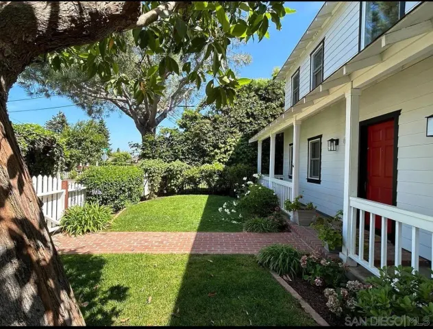 a view of a house with a yard and potted plants