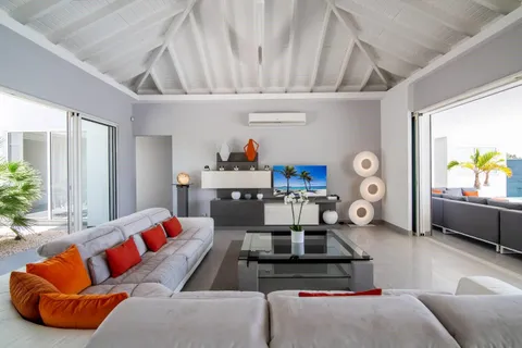 a living room with furniture kitchen view and a window