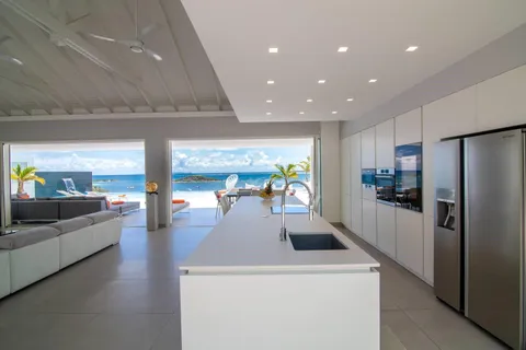 a view of living room with a couch and a dining table with kitchen view