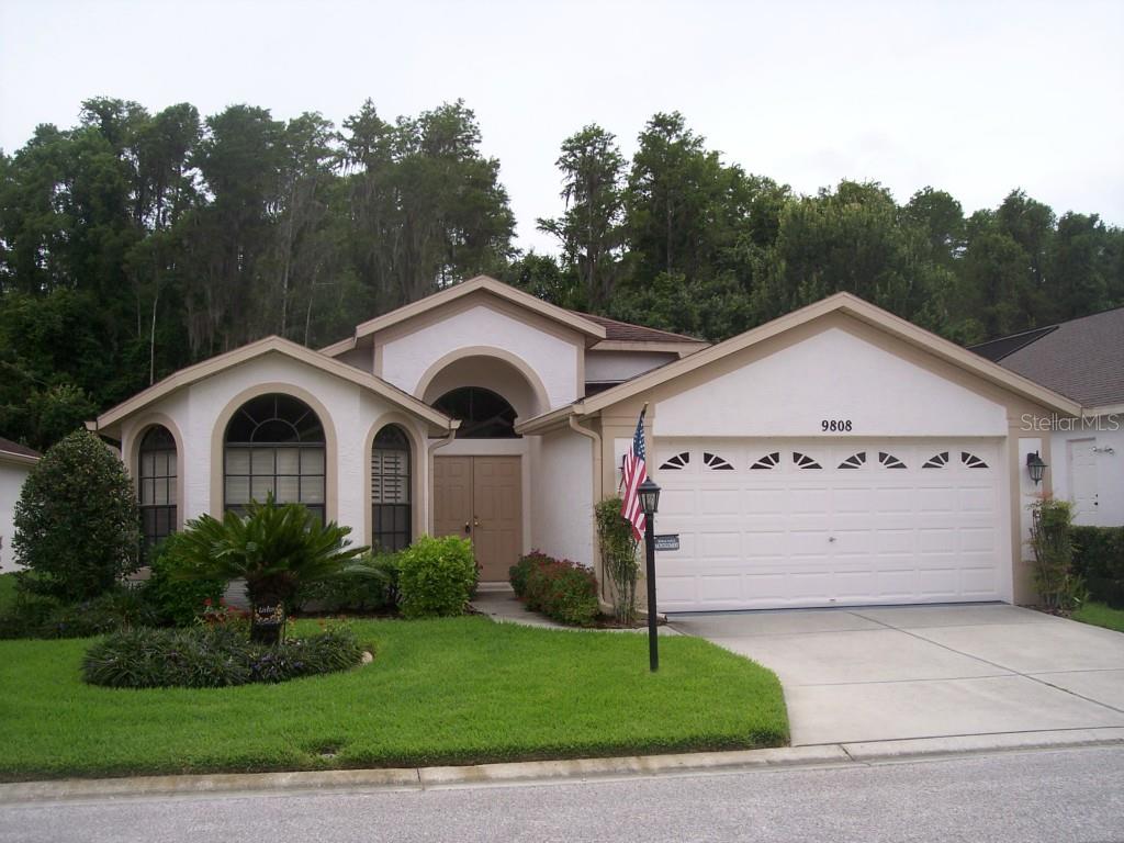 9808 Conservation Drive New Port Richey, FL 34655 - Photo 1 of 1 a view of a white house with a yard and large tree