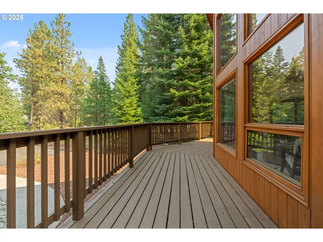 a balcony with wooden floor and yard in the back