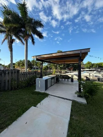 a view of a patio with a table and chairs under an umbrella with a big yard