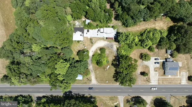 an aerial view of residential house with outdoor space and trees all around