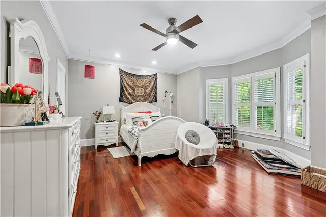 a bedroom with a bed window and a flat screen tv