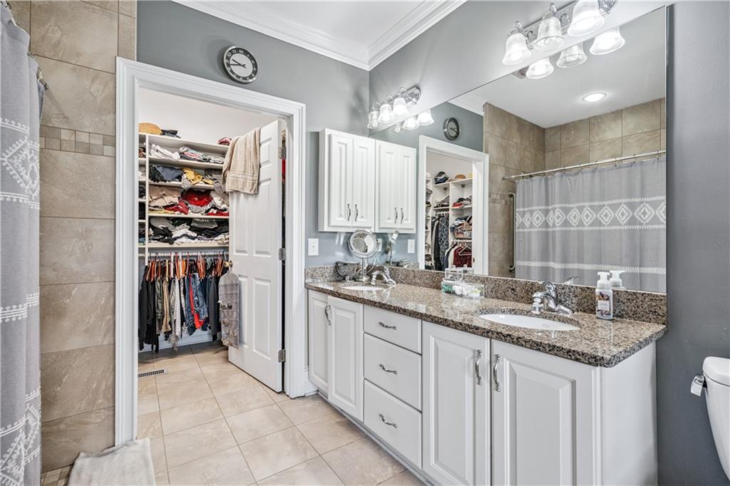 2012 Arbor Springs Way Buford, GA 30519 - Photo 23 of 61 a bathroom with a granite countertop sink a large mirror and a shower