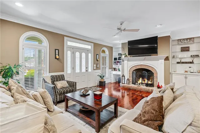 a bedroom with a bed a large window and wooden floor