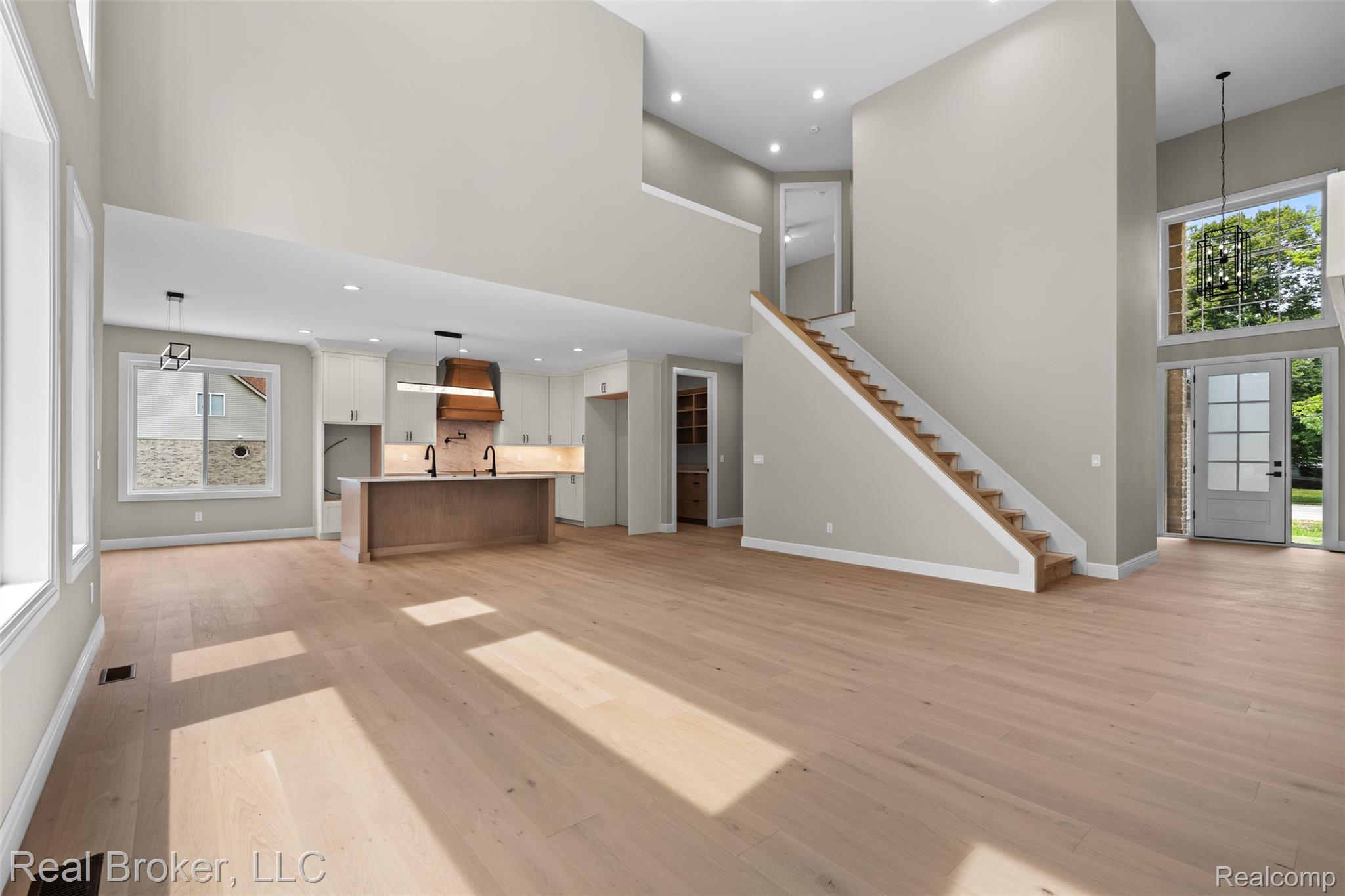 12114 22 Mile Road Utica, MI 48315 - Photo 15 of 70 Vaulted ceilings, light wood-finish flooring, and a modern kitchen with a wood-accented range hood
