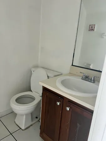 a bathroom with a sink toilet and a mirror