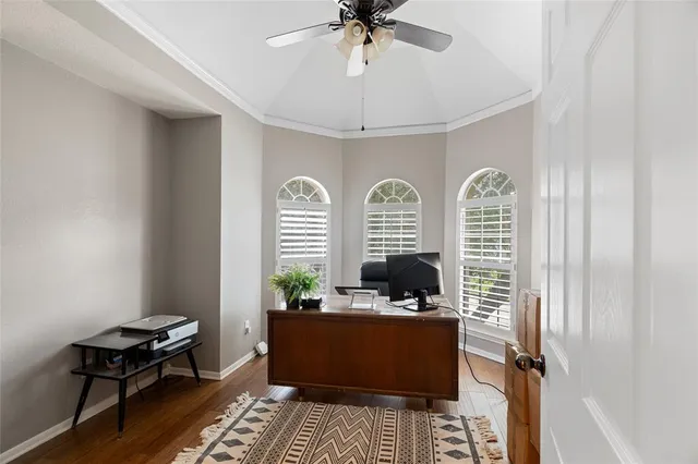 a room with chandelier fan and windows