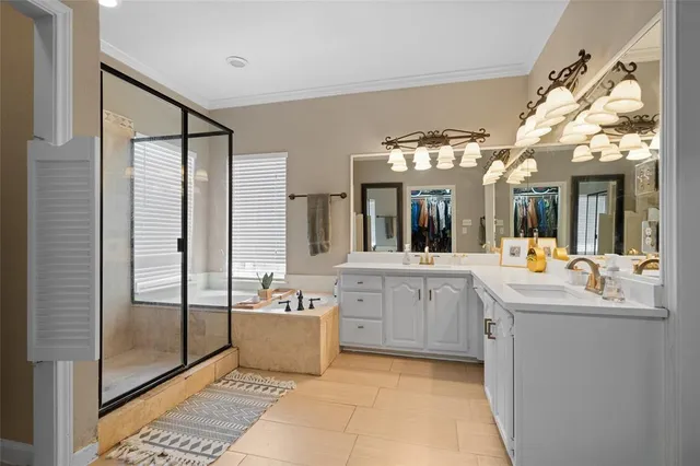a large white kitchen with a large window and stainless steel appliances