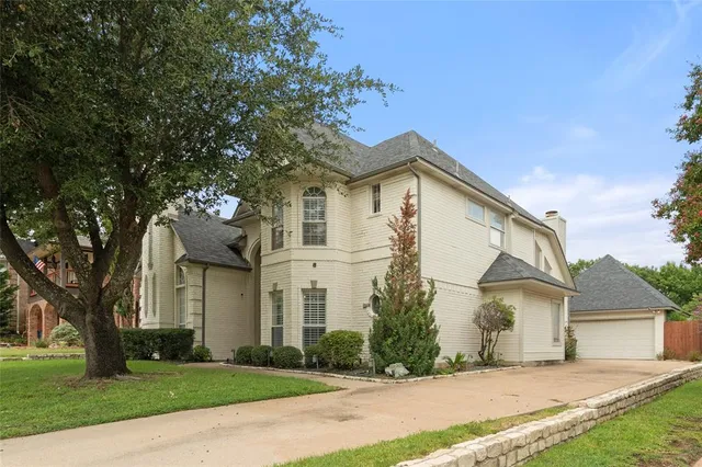 a front view of a house with a yard and trees