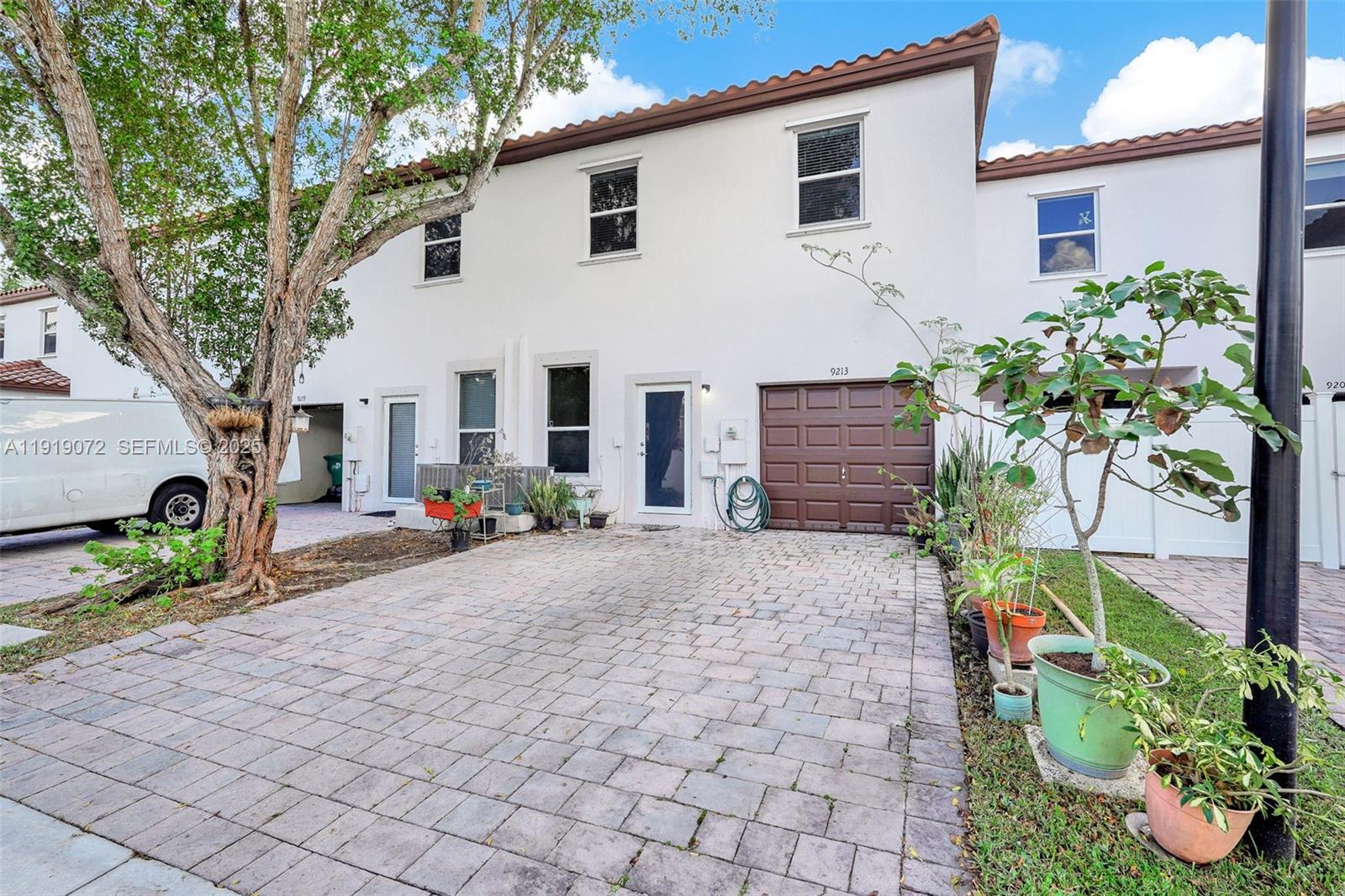 9213 Southwest 170th Avenue Miami, FL 33196 - Photo 12 of 82 a front view of a house with a yard and a garden