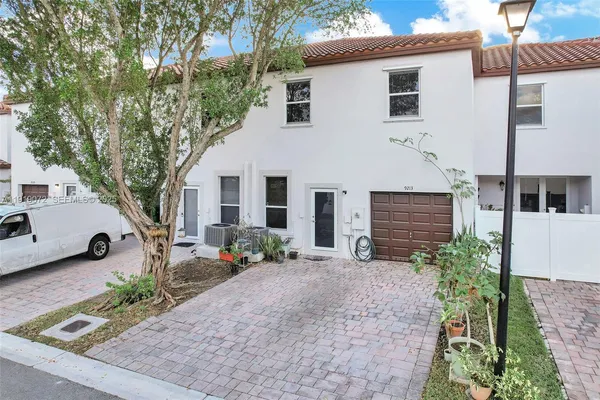 a front view of a house with a yard and a garden