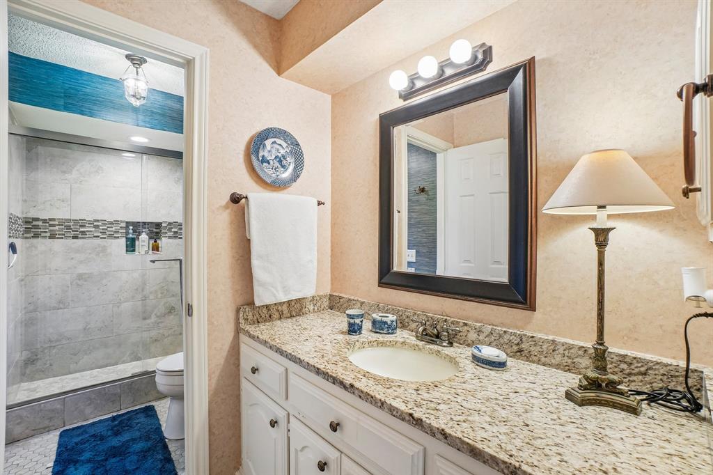 12929 Jasoncrest Trail Dallas, TX 75243 - Photo 18 of 38 Bathroom vanity featuring a speckled countertop and a built-in sink