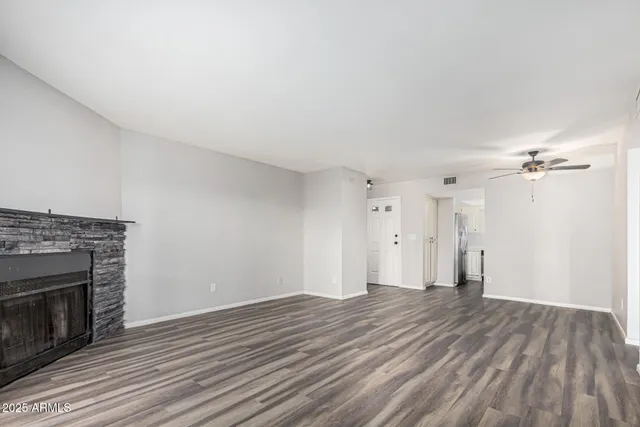 a view of empty room with wooden floor and fireplace