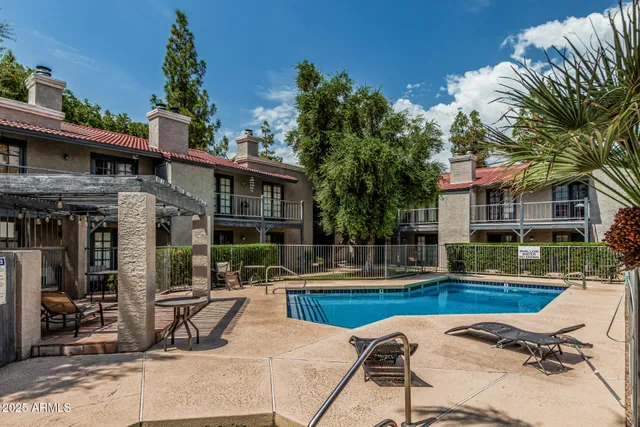 a view of a chairs and tables in patio with a barbeque