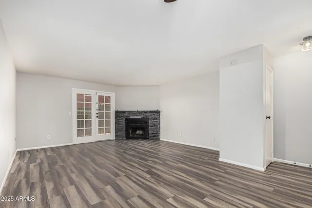 a view of empty room with wooden floor and fireplace