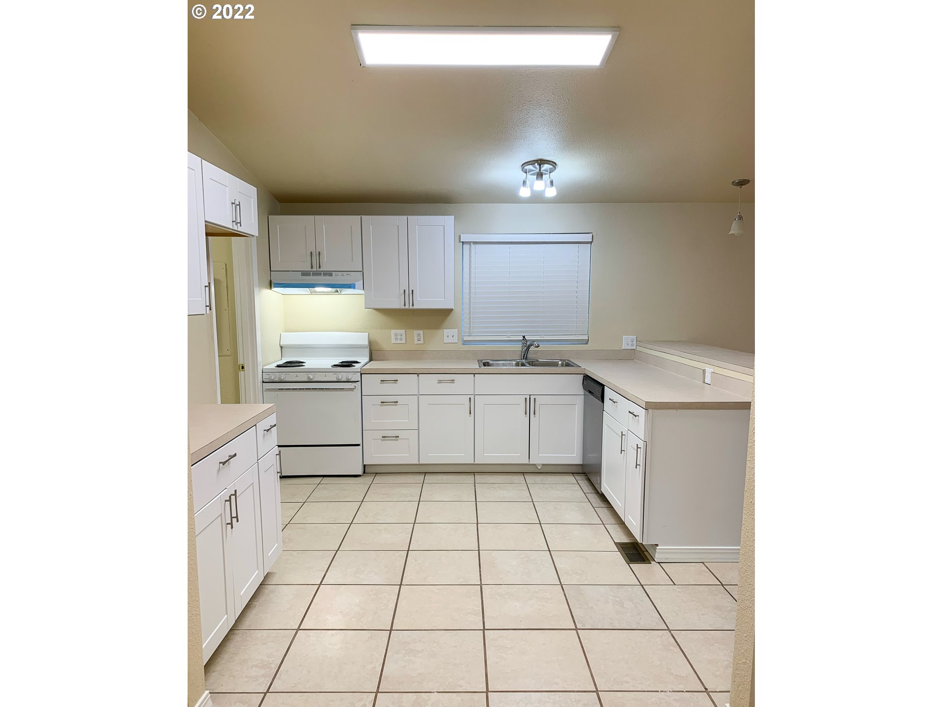 205 57th Street Springfield, OR 97478 - Photo 5 of 13 a kitchen with a sink a stove cabinets and a window