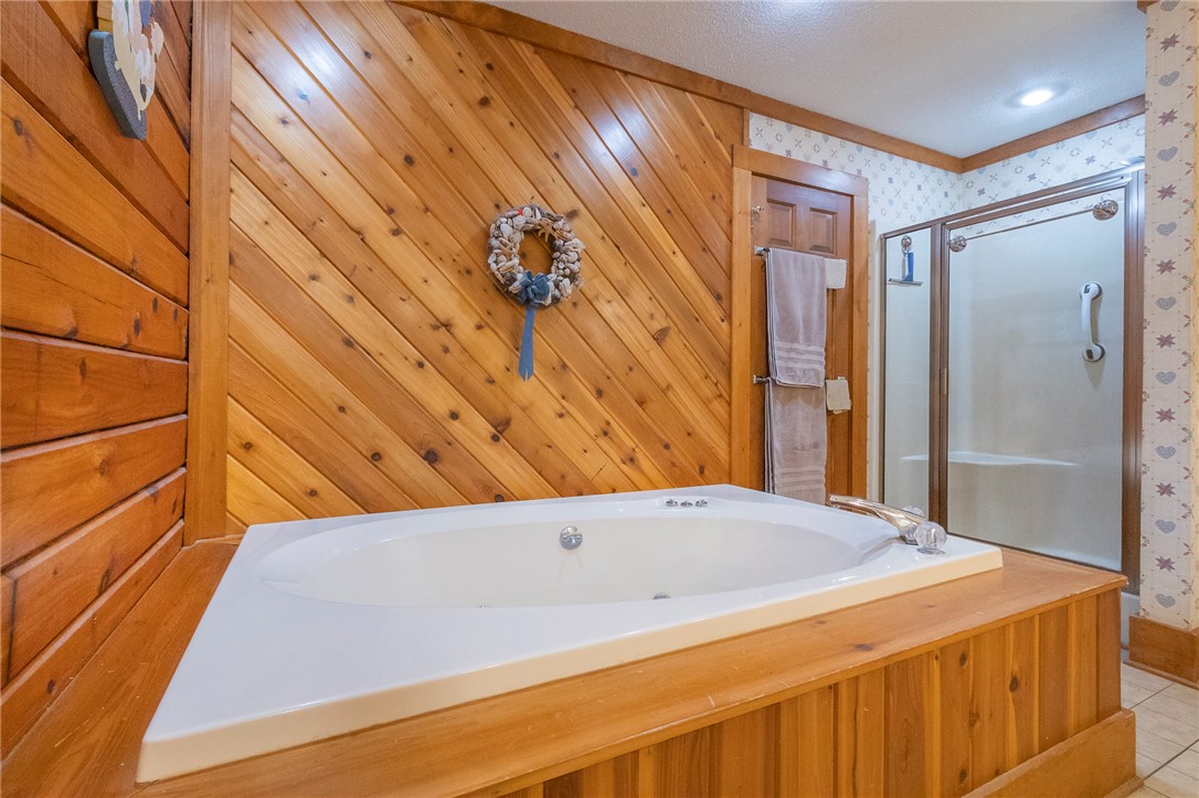 911 State Rd S-4-203 Belton, SC 29627 - Photo 25 of 49 Indulge in relaxation with this inviting soaking tub, complemented by warm wood paneling.