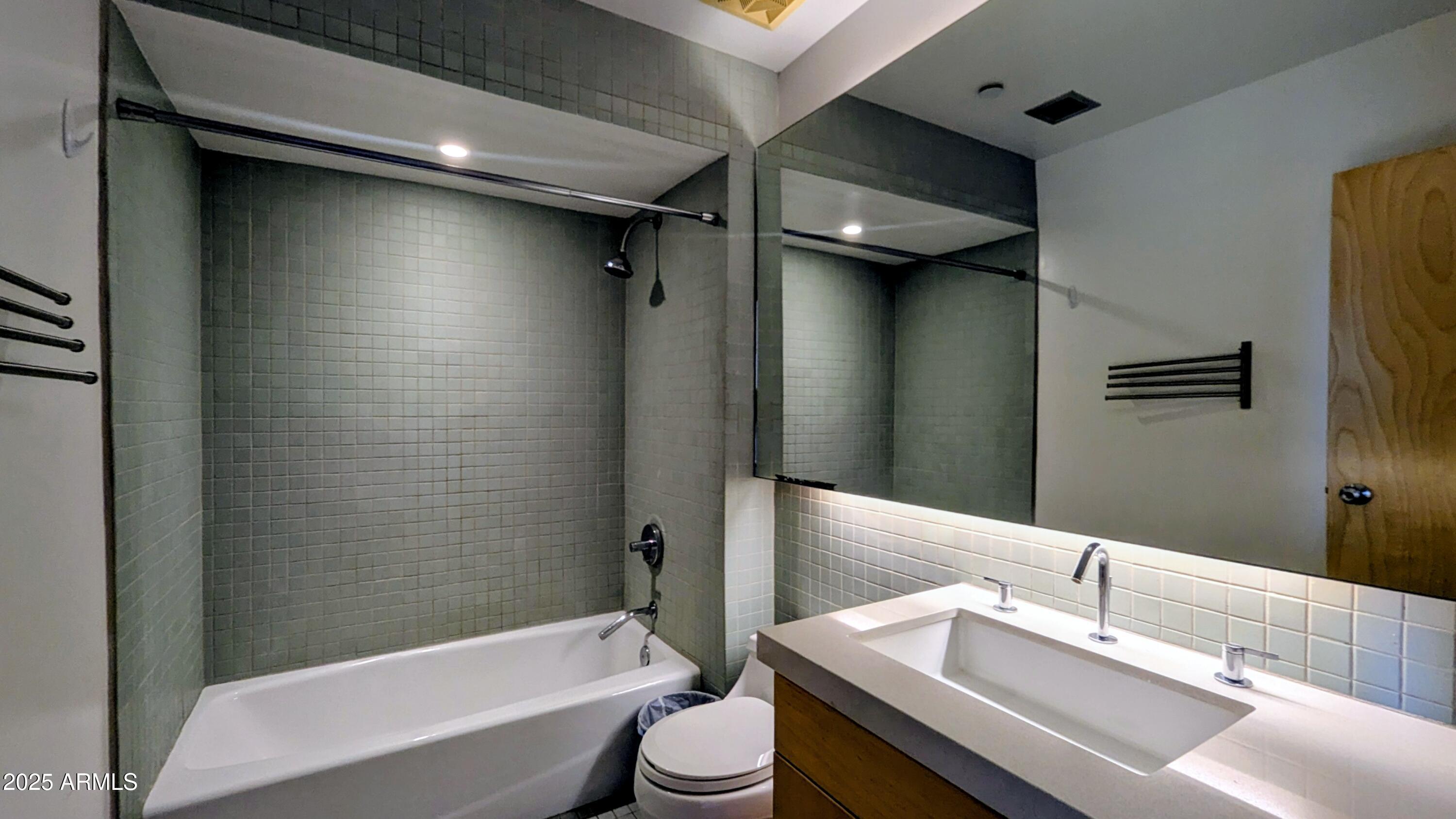 525 East Willetta Street, Unit 8 Phoenix, AZ 85004 - Photo 18 of 25 a bathroom with a granite countertop bathtub sink vanity mirror and toilet