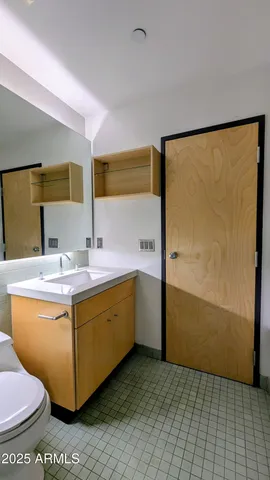 a bathroom with a sink mirror vanity and toilet