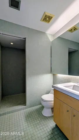 a bathroom with a toilet a sink and mirror