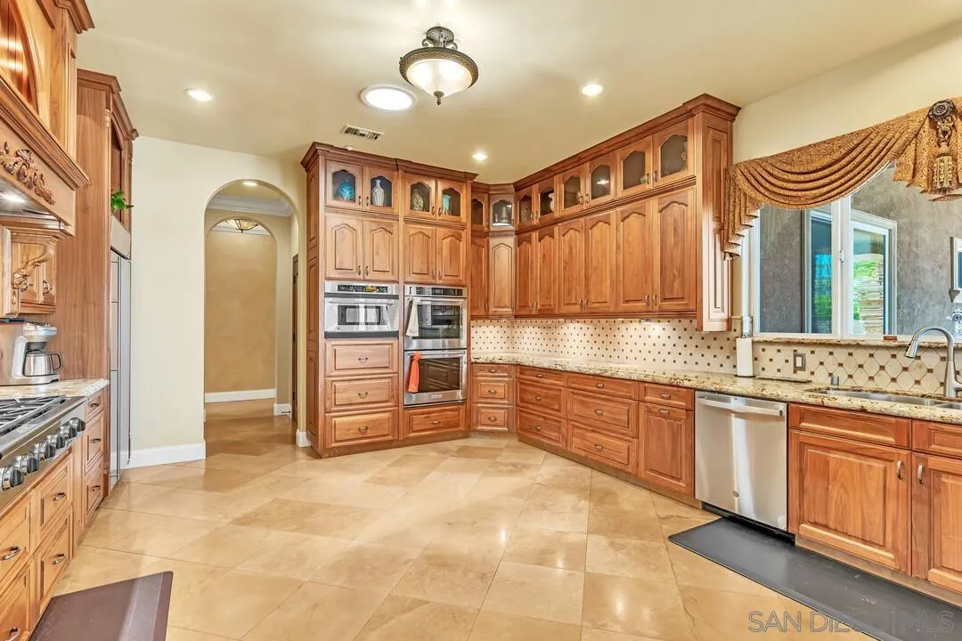 10321 Hitching Post Way Santee, CA 92071 - Photo 21 of 75 a large kitchen with stainless steel appliances a stove a sink and a refrigerator