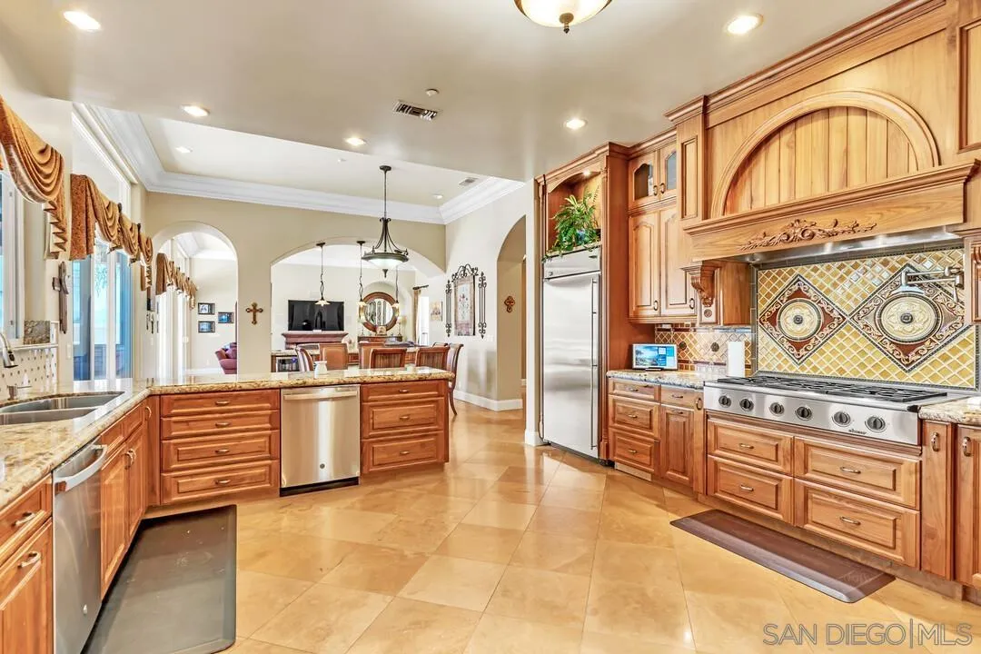 10321 Hitching Post Way Santee, CA 92071 - Photo 22 of 75 a large kitchen with stainless steel appliances granite countertop a stove a sink and a refrigerator