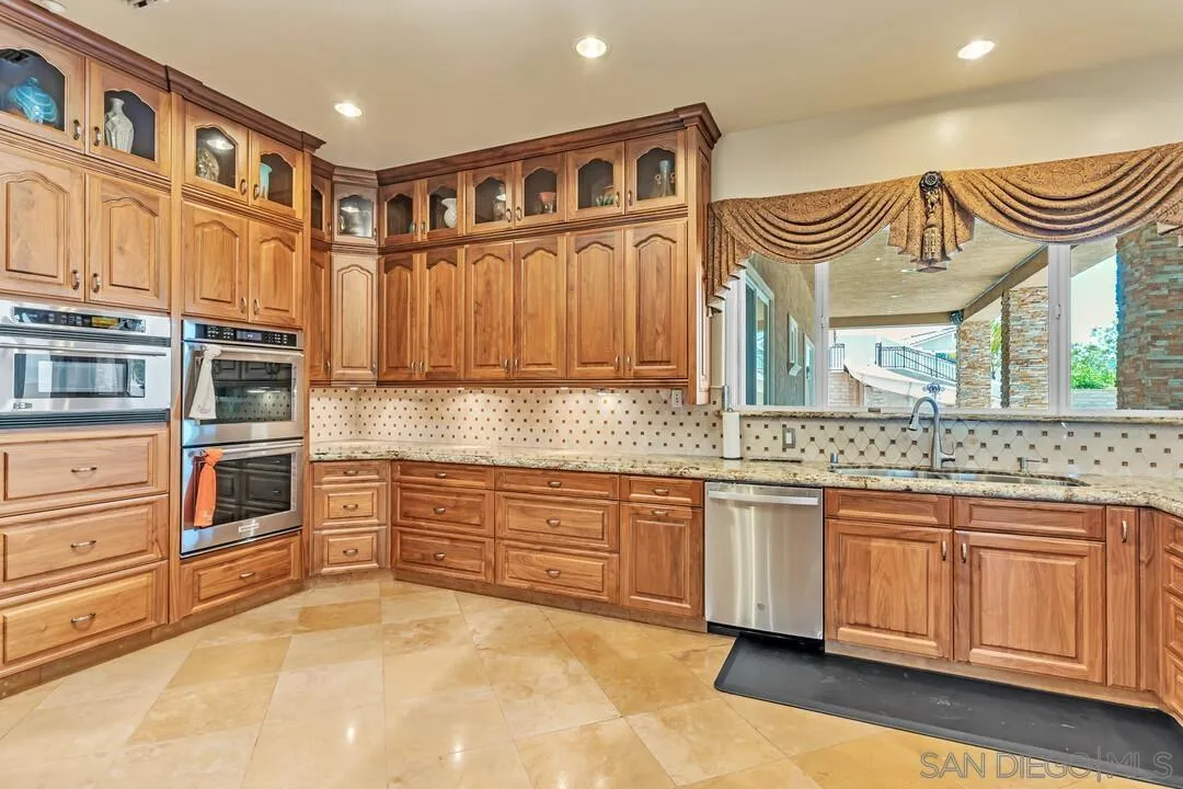 10321 Hitching Post Way Santee, CA 92071 - Photo 24 of 75 a kitchen with stainless steel appliances granite countertop a stove and cabinets