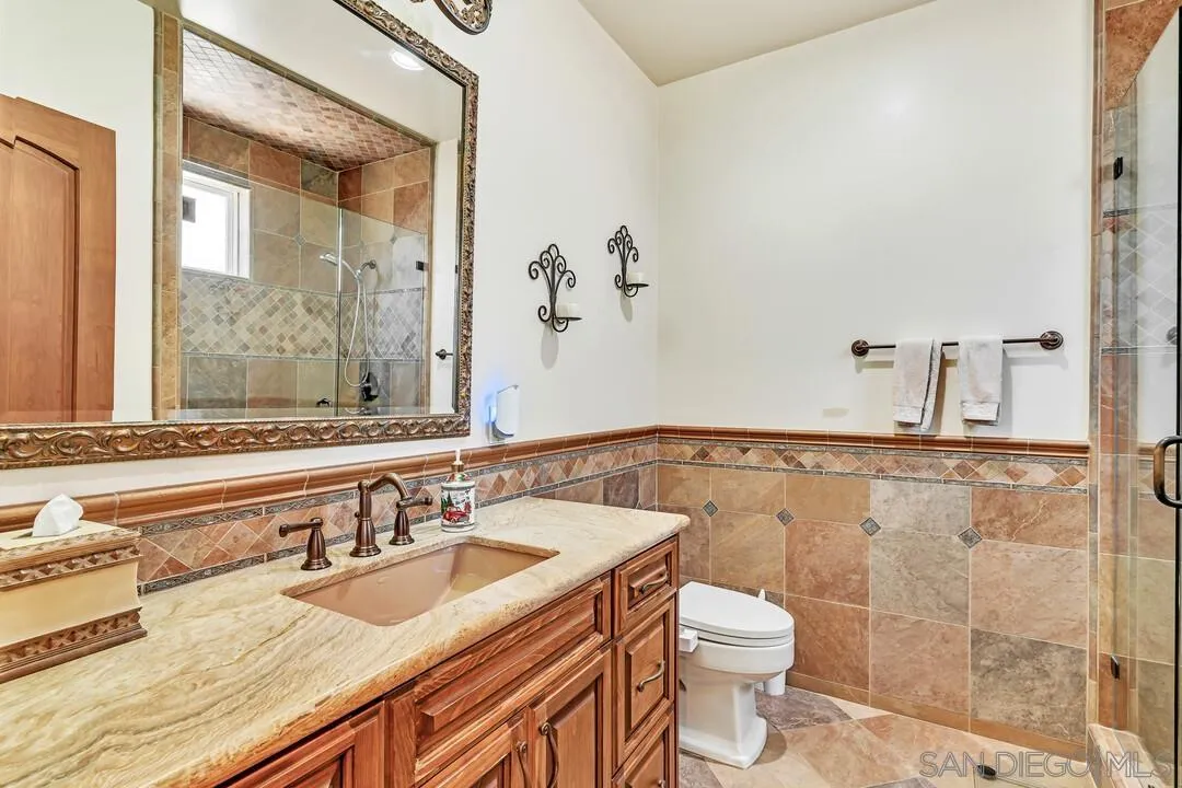 10321 Hitching Post Way Santee, CA 92071 - Photo 37 of 75 a bathroom with a granite countertop sink a toilet and a mirror