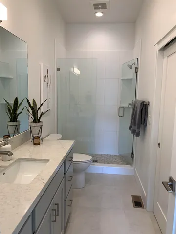 a bathroom with a sink a toilet and shower