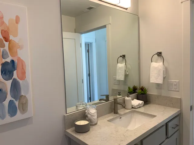 a bathroom with a granite countertop sink and a mirror