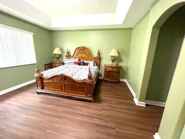 a bedroom with a bed and a wooden floor
