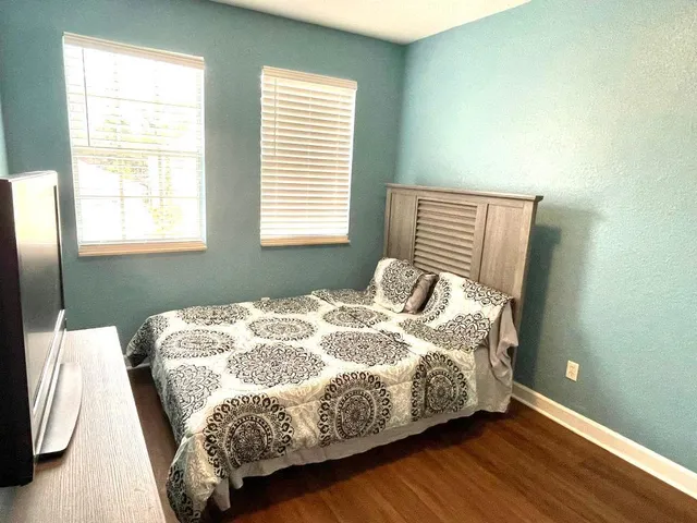 a bed sitting in a bedroom next to a window