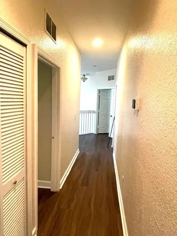a view of a hallway with wooden floor and staircase