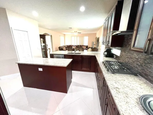 a large kitchen with a large counter top space appliances and wooden floor