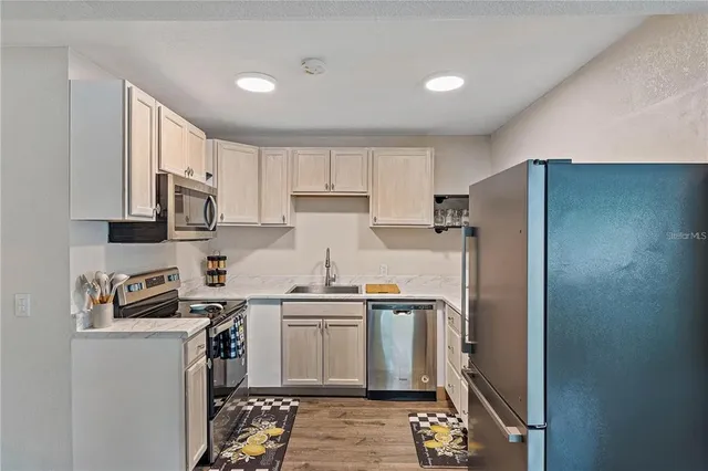 a kitchen with stainless steel appliances granite countertop a refrigerator sink and stove