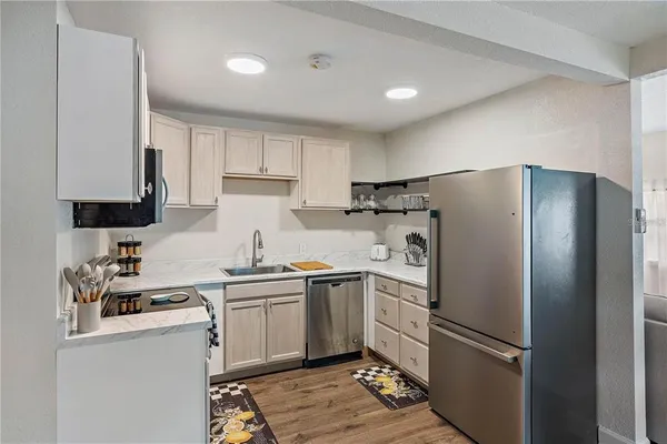 a kitchen with a refrigerator sink and white cabinets