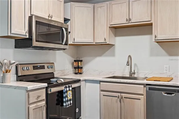 a kitchen with stainless steel appliances granite countertop a sink stove and microwave